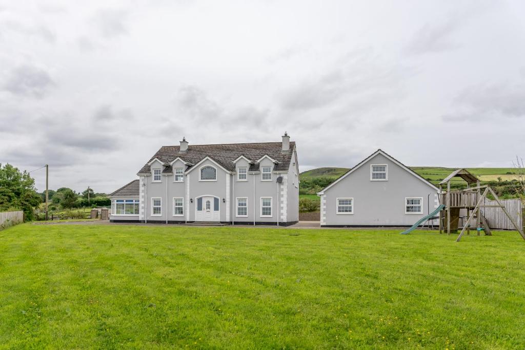 duży biały dom z dużym dziedzińcem w obiekcie Grianan Luxury Lodge by Wild Atlantic Wanderer w mieście Claragh