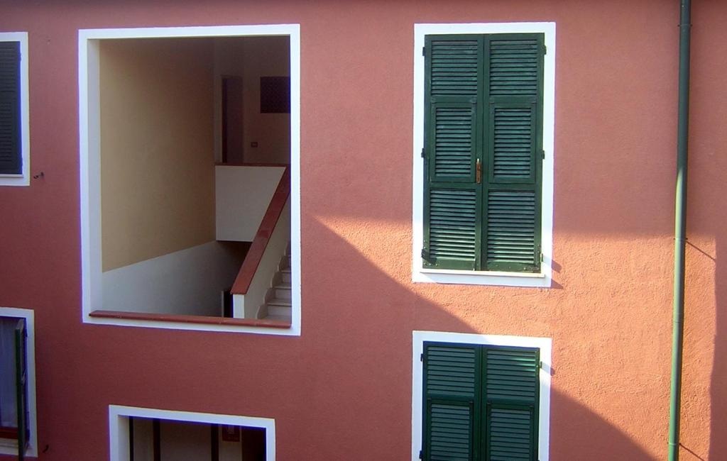 a pink building with a window and a mirror at Casavacanze Zeus in Marciana Marina