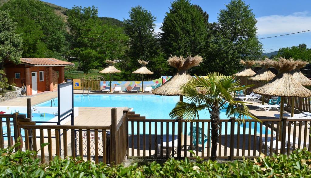 un complejo con una piscina con sombrillas en Camping Calme et Nature Iserand, en Vion
