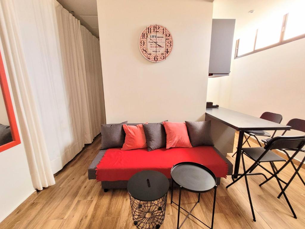 un soggiorno con divano rosso e tavolo di La Arena studio a Puerto de Santiago