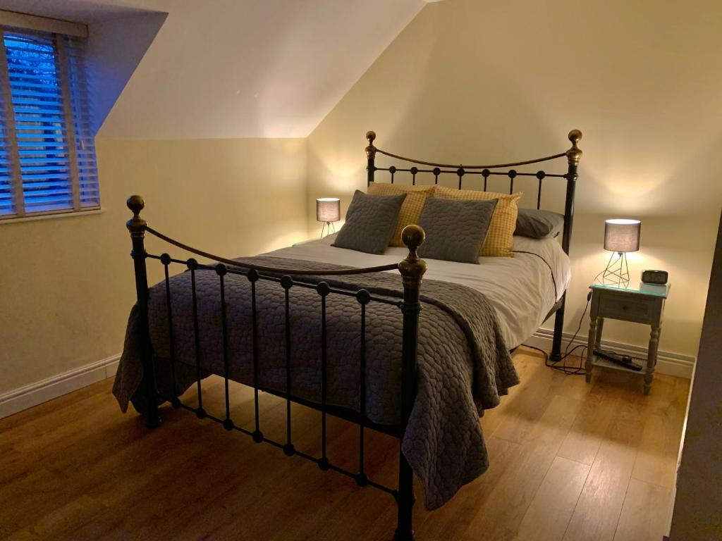 ein Schlafzimmer mit einem großen Bett in einem Zimmer in der Unterkunft Kellsboro Corner in Fairford