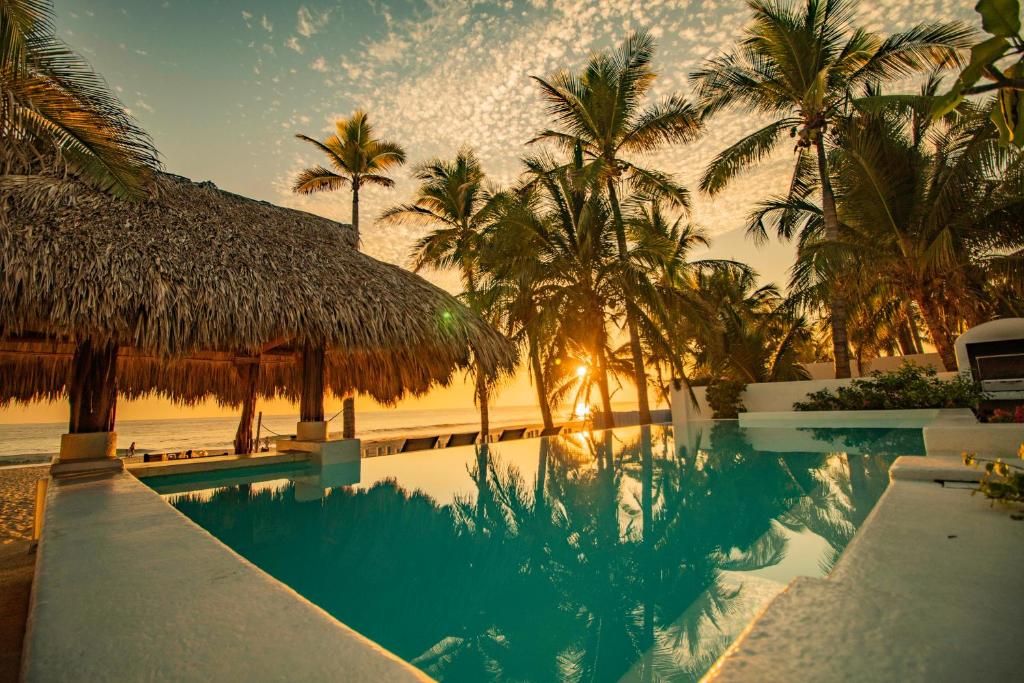 un complejo con una piscina con palmeras en Villa Rincon del Mar & Villa Rincon de las Morenas, en Coyuca