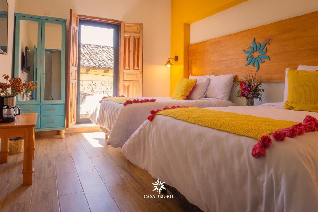 a hotel room with two beds and a window at Hotel Casa del Sol in San Cristóbal de Las Casas