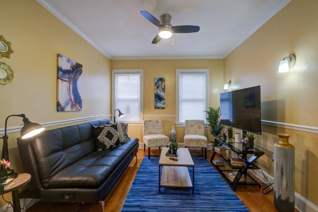 sala de estar con sofá de cuero y TV en Spacious apartments near Ashmont - Evonify Stays, en Boston