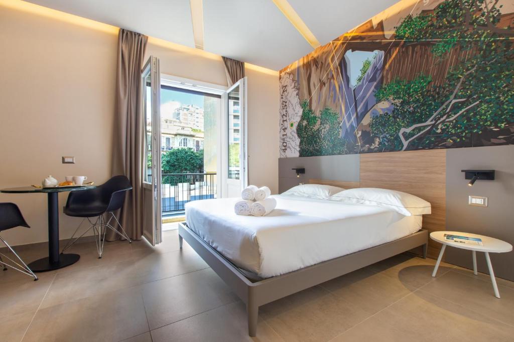 1 dormitorio con 1 cama y una gran pintura en la pared en ARKADIA Rooms & Apartments, en Cagliari