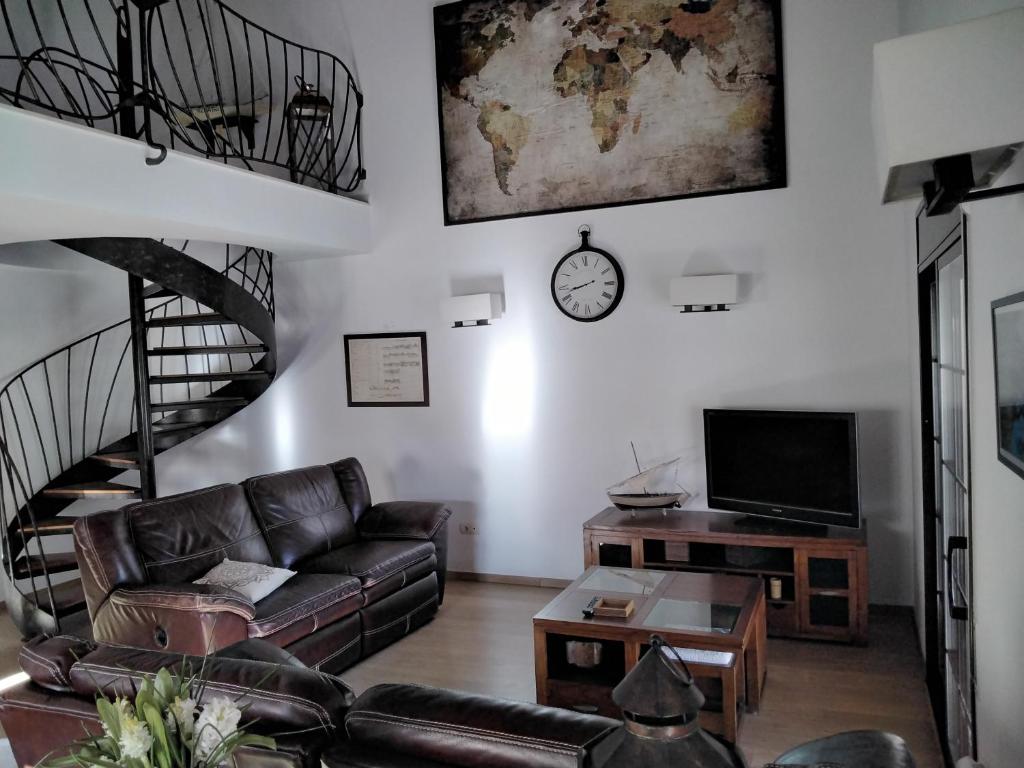 uma sala de estar com um sofá e uma escada em espiral em Casa Paca em Deltebre