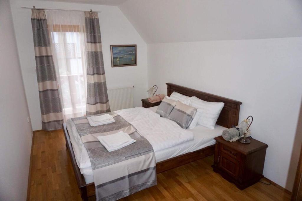 sypialnia z łóżkiem i oknem w obiekcie Emese Apartman Cserszegtomaj w mieście Cserszegtomaj