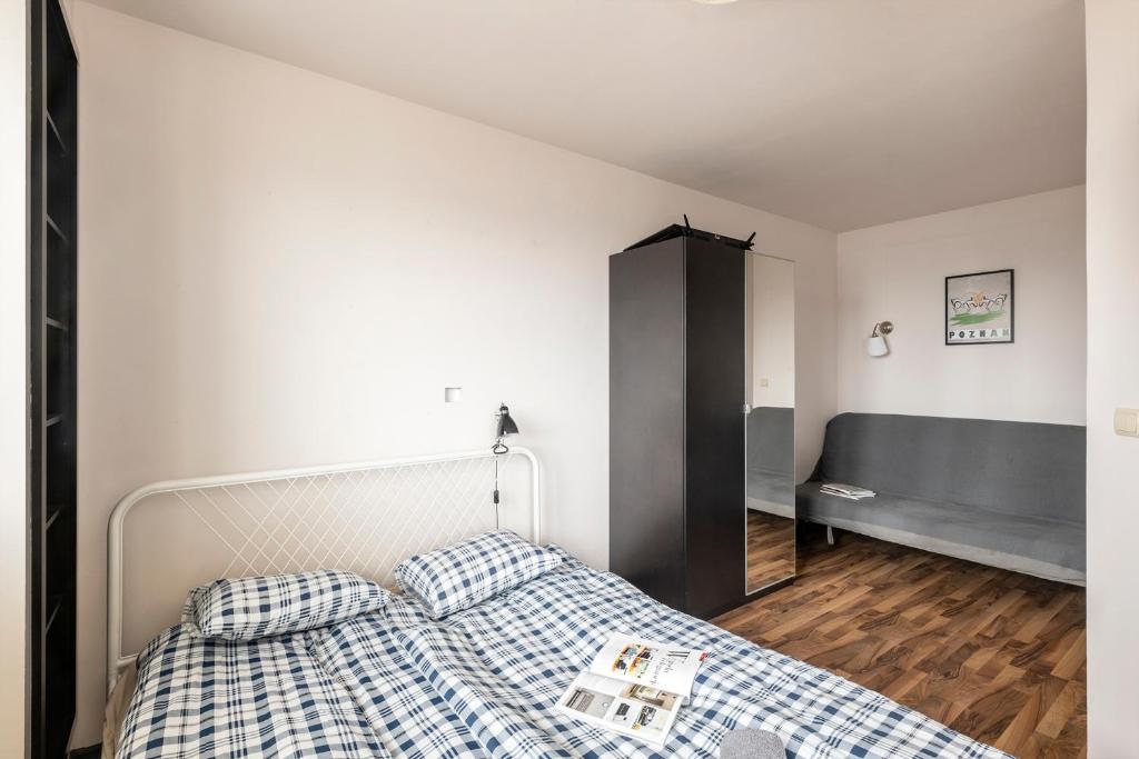 Schlafzimmer mit einem Bett mit blauer und weißer Bettwäsche in der Unterkunft Pokoje Bukowińska in Warschau