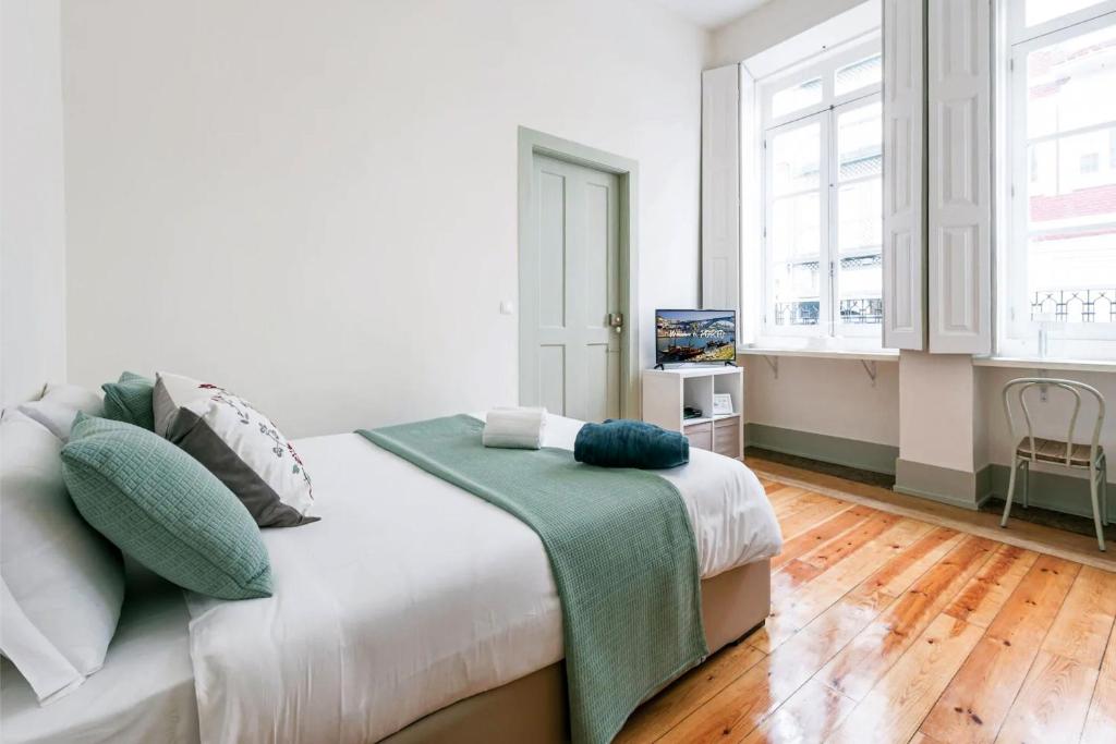 ein Schlafzimmer mit einem Bett mit einer grünen Decke darauf in der Unterkunft In Lapa Studio I in Porto