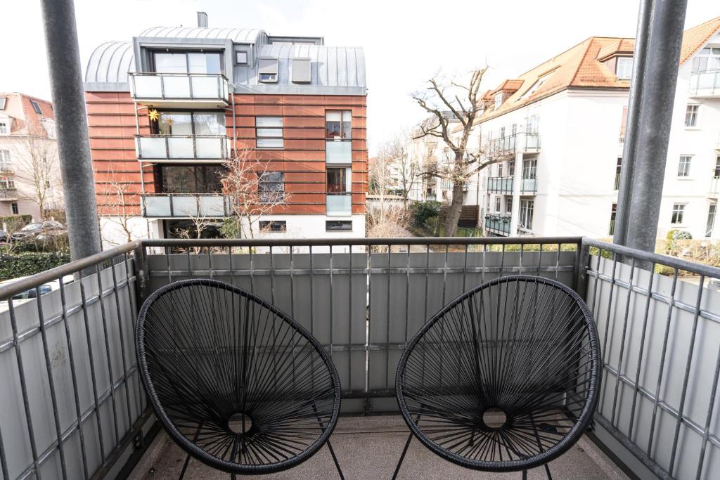 un balcón con 2 asientos para bicicletas en una valla en Stylisches Apartment im Herzen von Dresden + Parkplatz + Netflix + Self Check-in, en Dresden