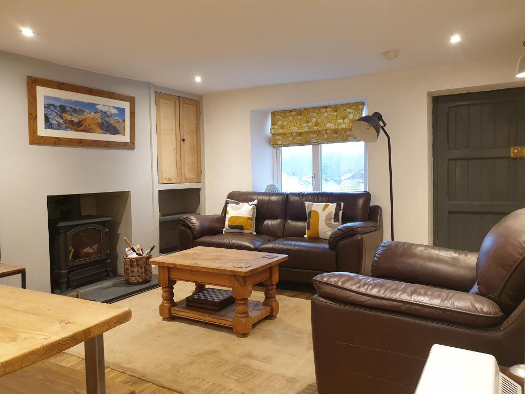 a living room with leather furniture and a fireplace at No8 3 bed cottage Winter Deals offered 3 nights or more Nov-Mar in Backbarrow
