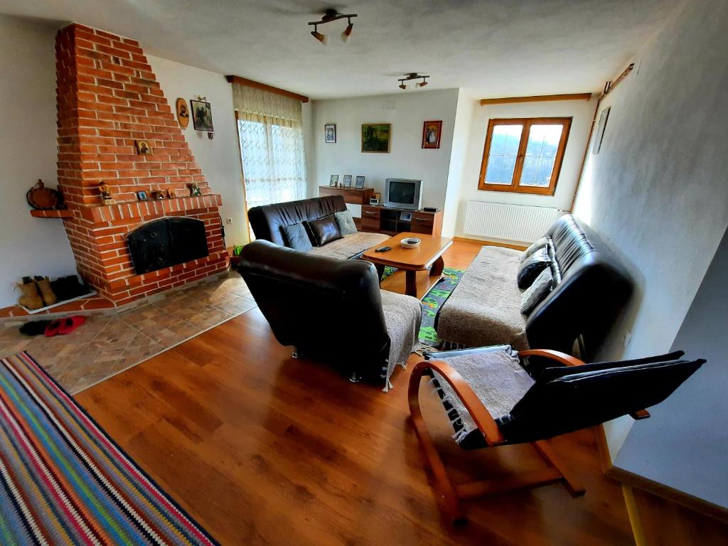 sala de estar con muebles de cuero y chimenea en Kuća na dan Vrla strana en Bosansko Petrovo Selo