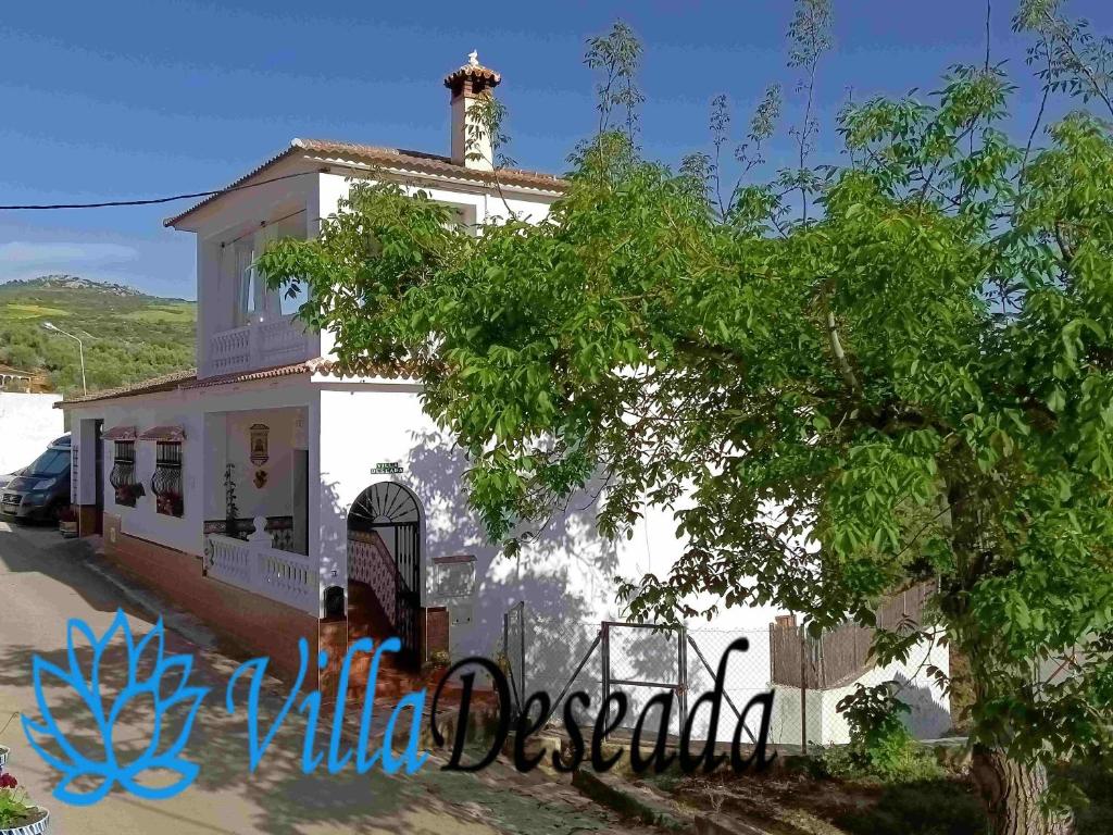 a white house with a tree in front of it at B&B Villa Deseada in Periana