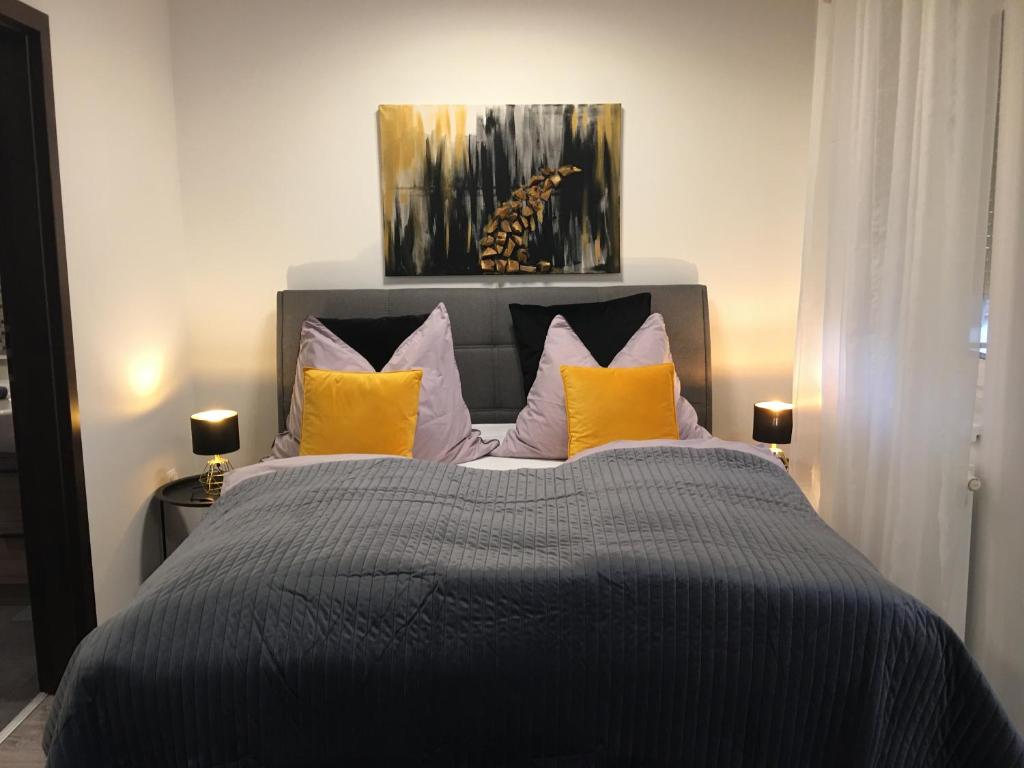 1 dormitorio con 1 cama con almohadas moradas y amarillas en HOME Apartment, en Sopron
