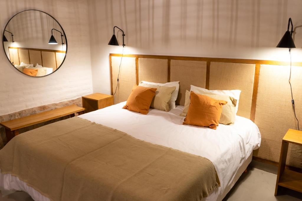 1 dormitorio con 1 cama grande con almohadas de color naranja en Gardenia en San Javier