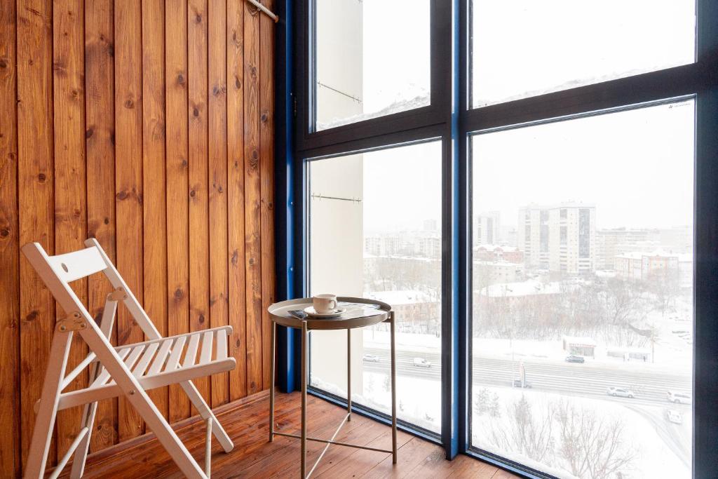 a chair and a table in a room with a window at Apart Sdaem116 Studio in Kazan