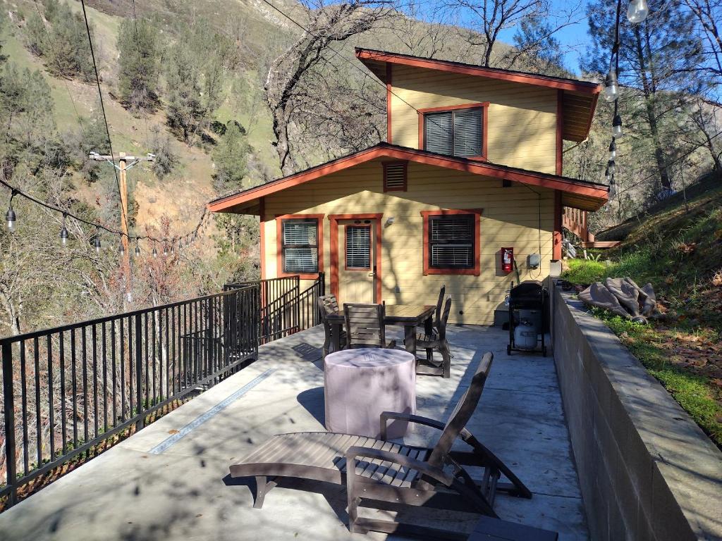 een huis met een tafel en stoelen ervoor bij Yosemite Gatekeeper's Lodge in El Portal
