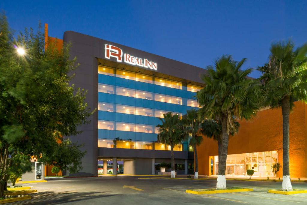 a hospital building with palm trees in front of it at Real Inn Nuevo Laredo in Nuevo Laredo