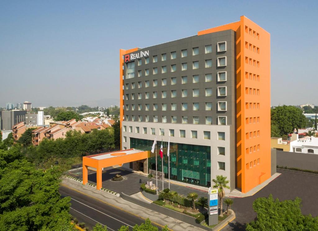 een oranje en wit gebouw naast een straat bij Real Inn Guadalajara Expo in Guadalajara