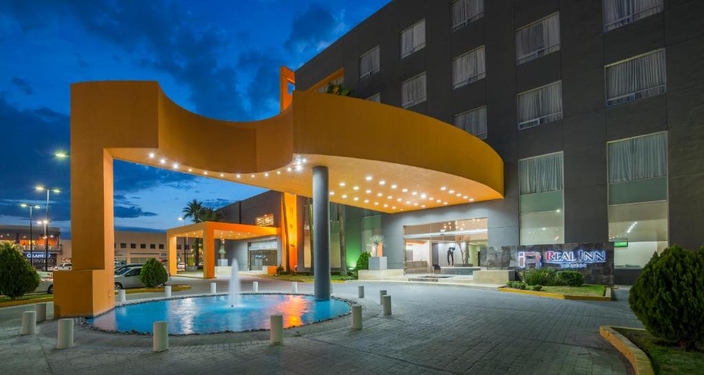 un hotel con un gran edificio con una fuente en Real Inn Torreon en Torreón