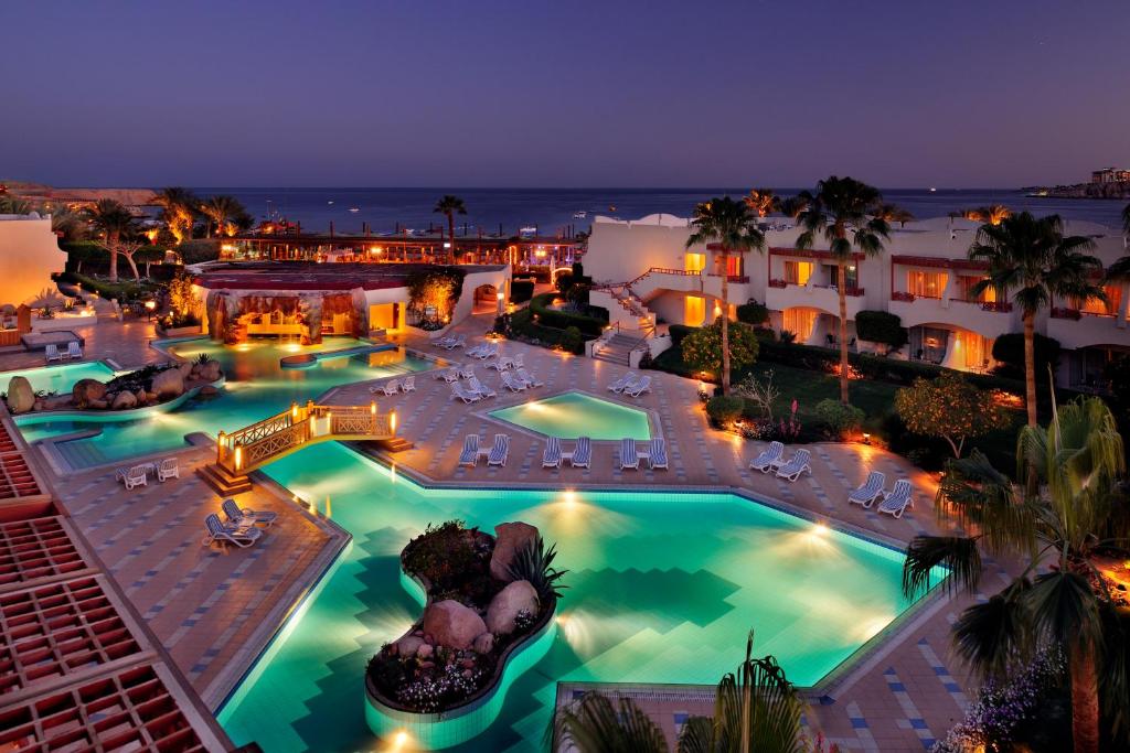 an aerial view of a resort pool at night at Naama Bay Promenade Beach Resort Managed By Accor in Sharm El Sheikh