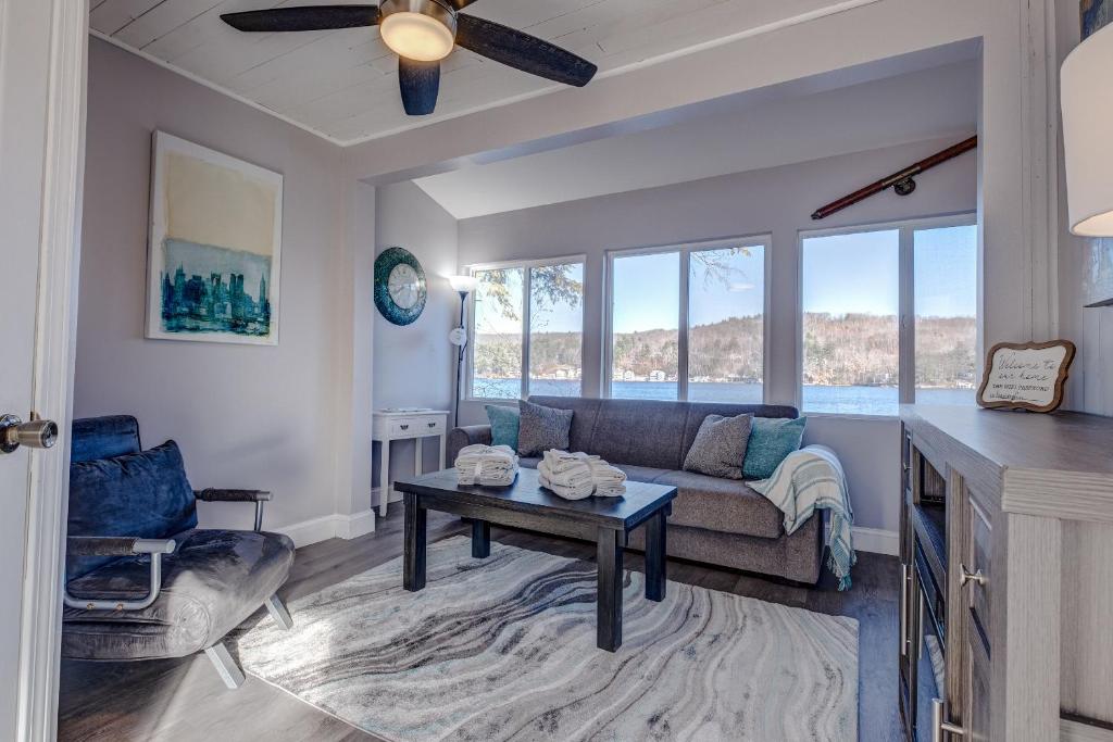 a living room with a couch and a table at Modern Winnipesaukee Lake Front Retreat (Venice) in Alton