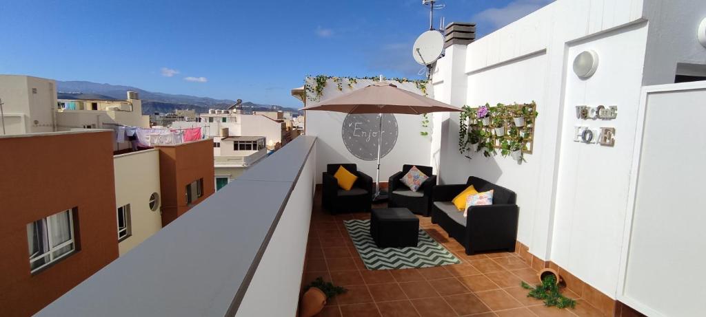 a balcony with chairs and an umbrella on a building at MOWANI'S STUDIO in Las Palmas de Gran Canaria