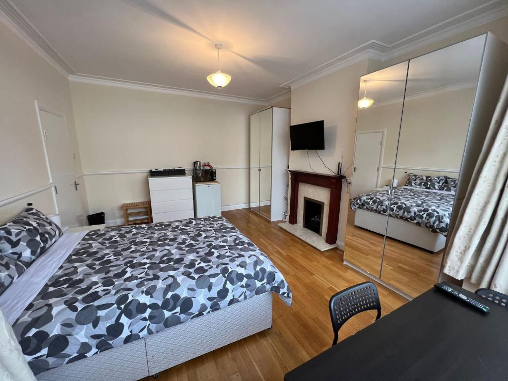 a bedroom with a bed and a fireplace at Gladstone Lodge in London