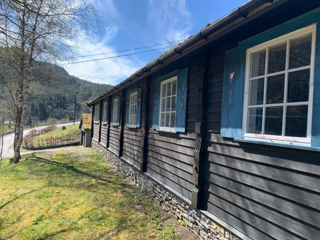 una casa di legno con finestre e un cortile erboso di Voss/Bolstad: Peaceful countryside cabin/lodge a Bolstadøyri