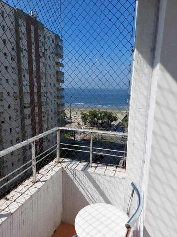 Un balcón con una silla y vistas al océano. en Vista&Aconchego en Santos