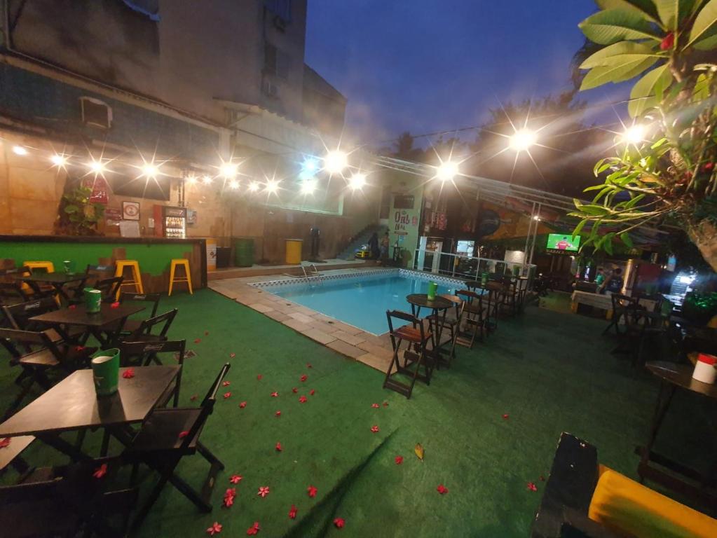 a swimming pool with tables and chairs in a building at Maraca Hostel in Rio de Janeiro