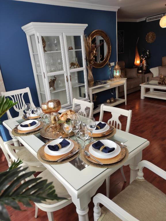 - une table à manger blanche avec des assiettes de nourriture dans l'établissement Caprichos, à Jerez de la Frontera