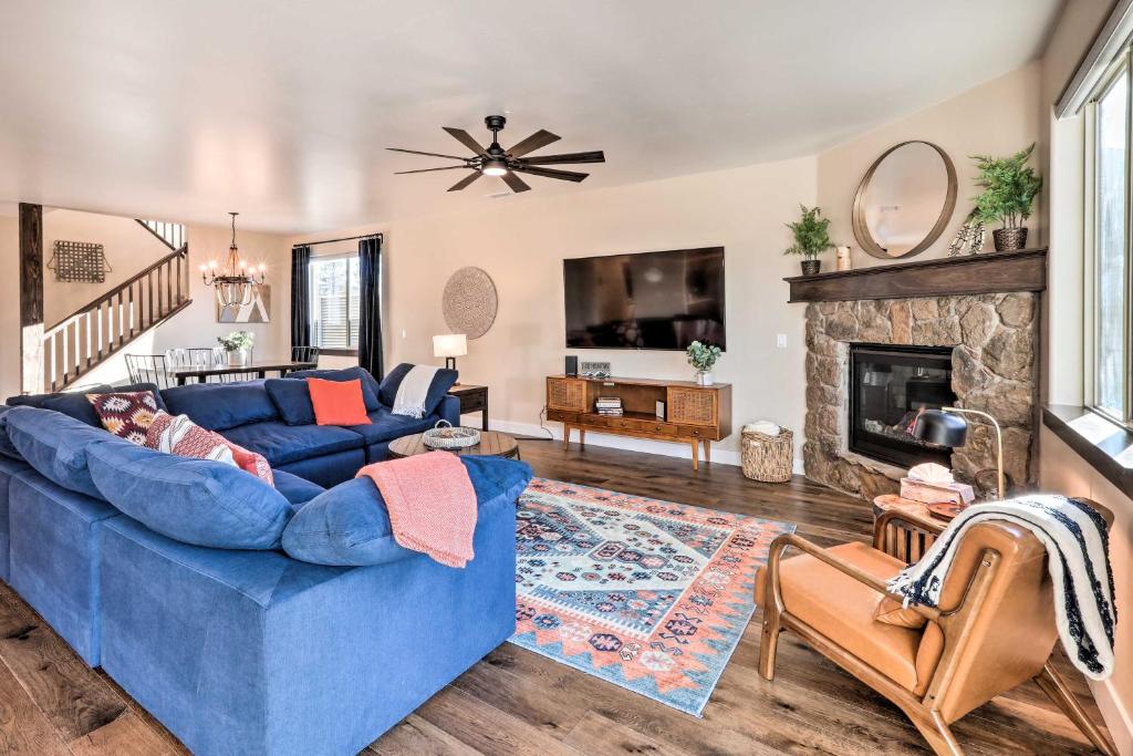 Una sala de estar con un sofá azul y una chimenea. en Modern Flagstaff Retreat with Fire Pit and EV Charger!, en Flagstaff