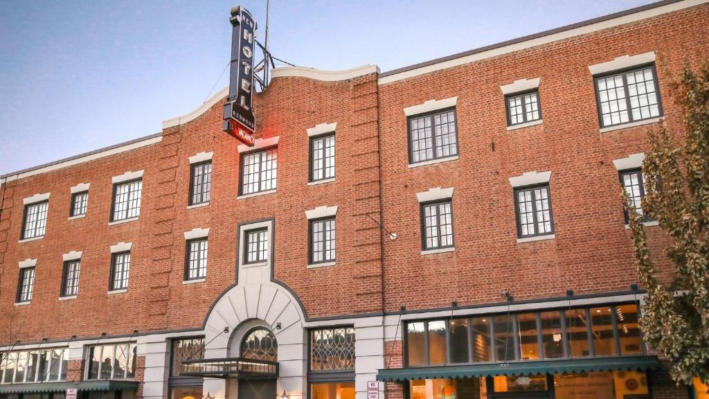 a red brick building with a sign on it at SCP Redmond Hotel in Redmond