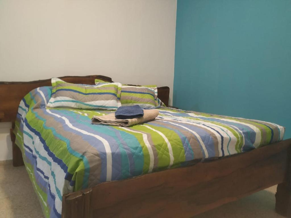 a bed with a colorful comforter and two pillows at MI CASA APARTS in Tunuyán