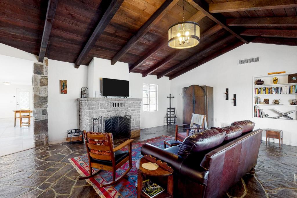 a living room with a leather couch and a fireplace at Lazy C Ranch in Tucson