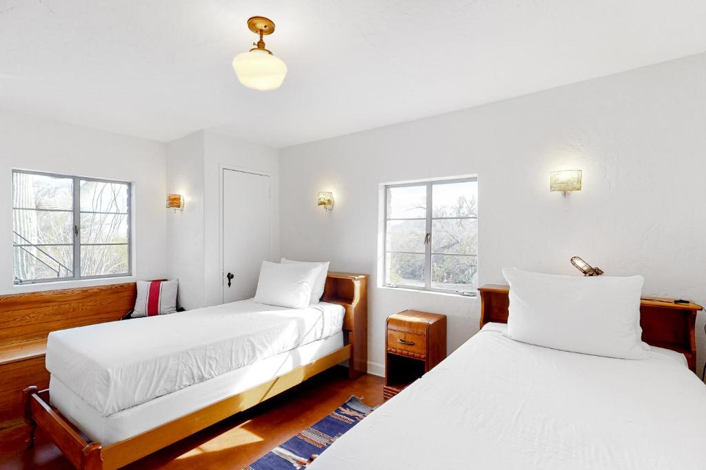 two beds in a room with white walls and windows at Lazy C Ranch in Tucson
