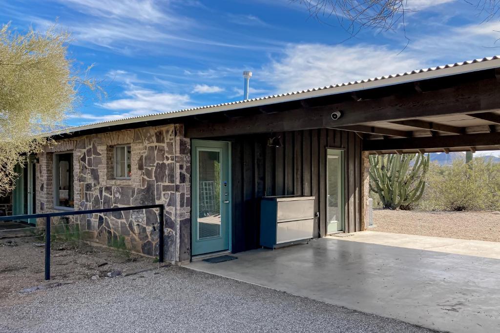 a stone house with a blue door and a porch at Lazy C Ranch in Tucson