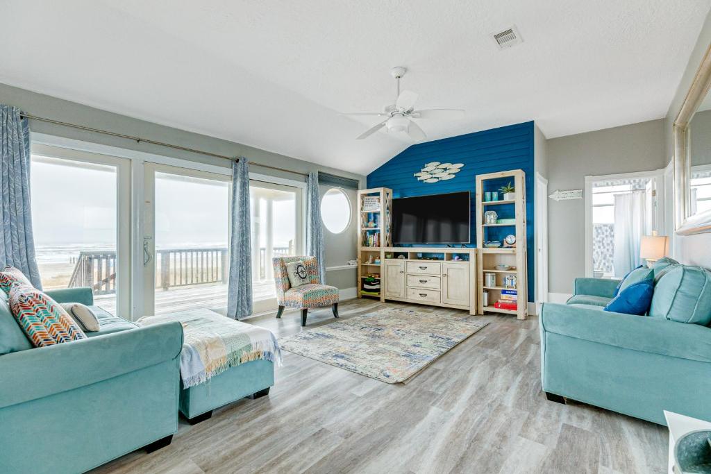 a living room with a couch and a tv at Times Like These in Galveston