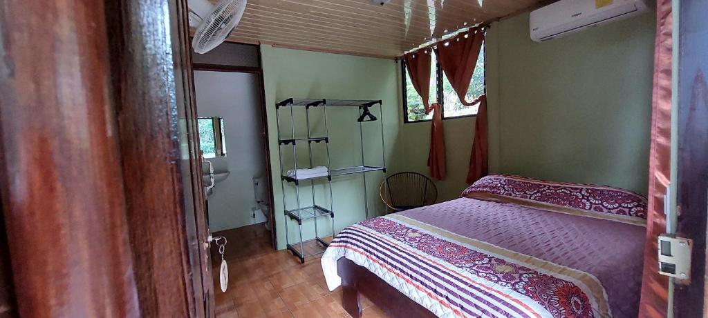 Hostal y cabinas anita-and rafting tour! في Siquirres: غرفة نوم بسرير ومغسلة في غرفة