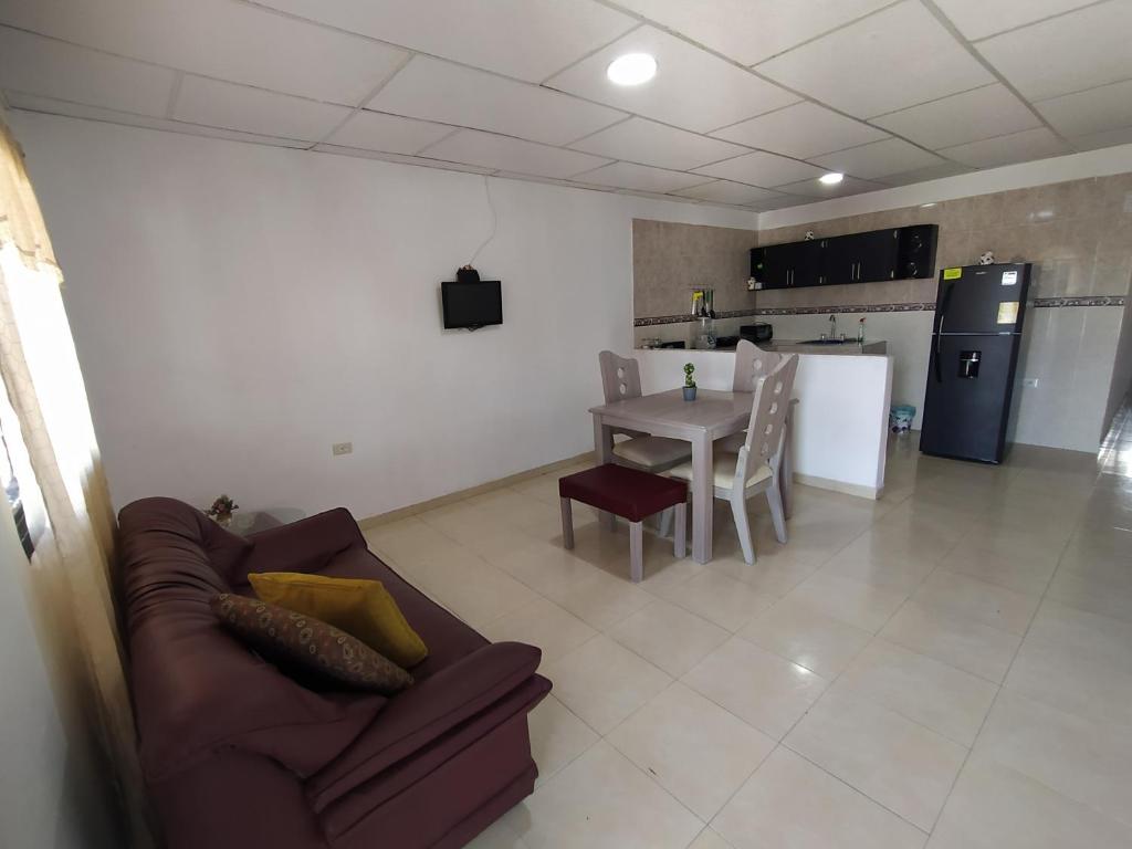 uma sala de estar com um sofá, uma mesa e uma cozinha em Apartamento #3 completo en excelente ubicación em Ríohacha