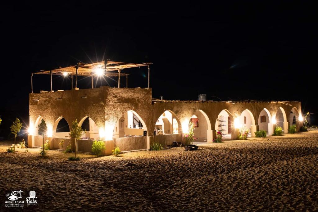 ein altes Gebäude mit Lichtern in der Nacht in der Unterkunft Hayaat siwa hot spring in Siwa