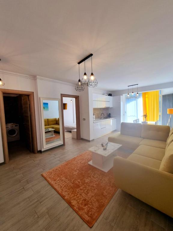 een woonkamer met een bank en een tafel bij Apartament SIMINA ALZ -2 camere in Mamaia Nord – Năvodari