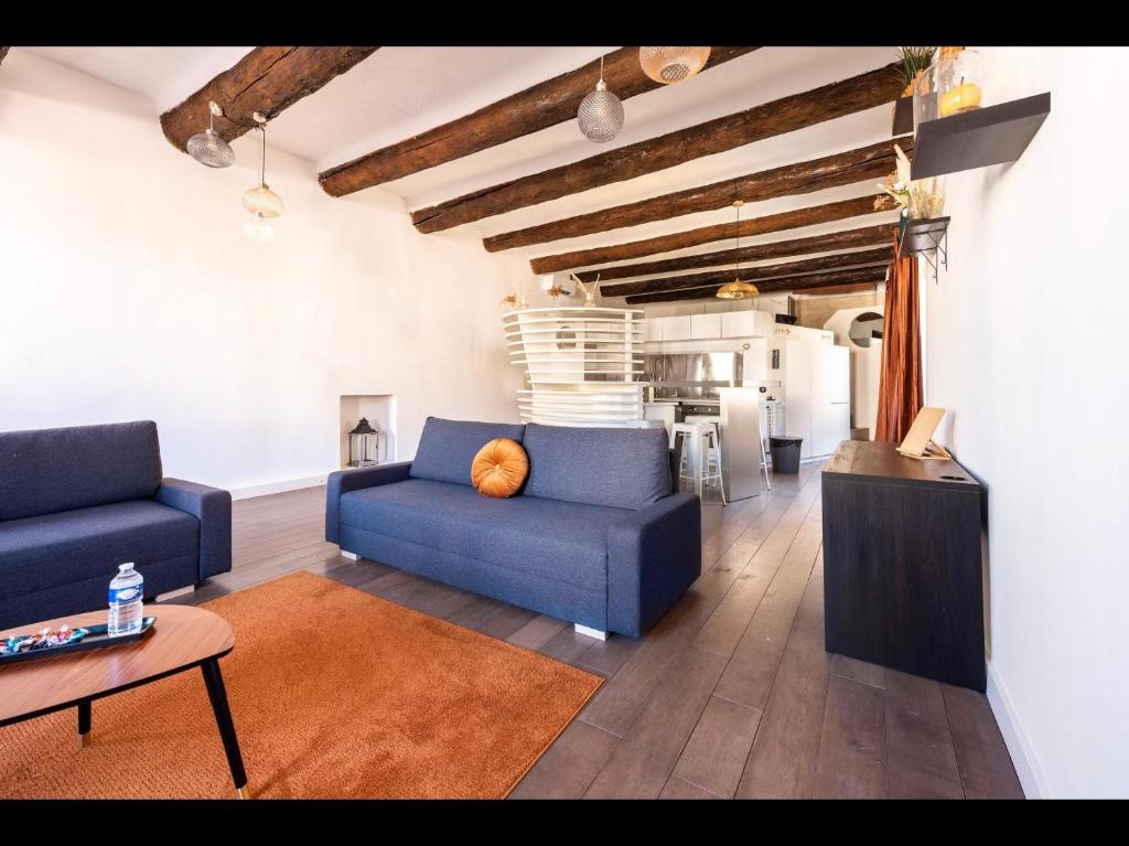 a living room with two blue couches and a kitchen at LOFT VIEUX PORT in Marseille