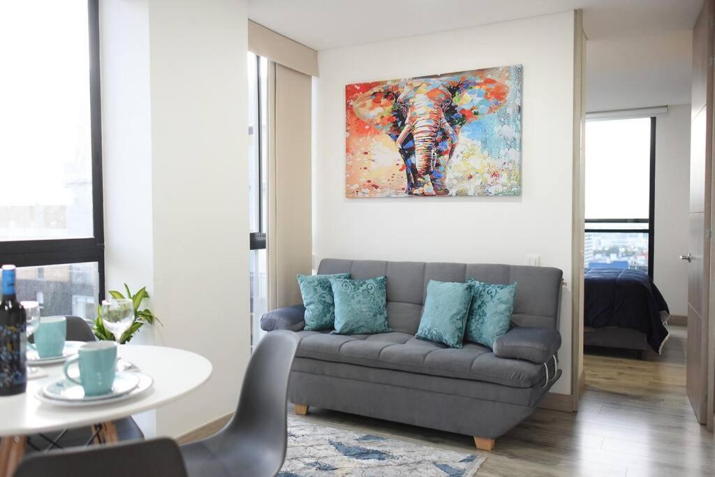 a living room with a couch and a painting on the wall at Downtown Bogota Centro Internacional in Bogotá