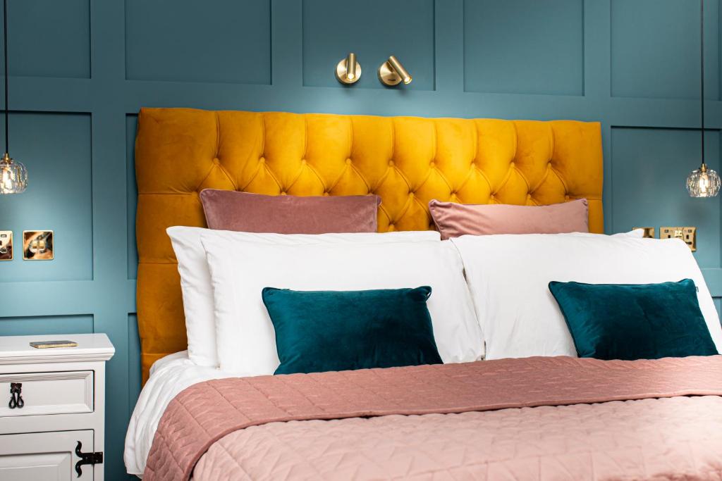 a bedroom with a large bed with a yellow headboard at Afon View in Betws-y-coed