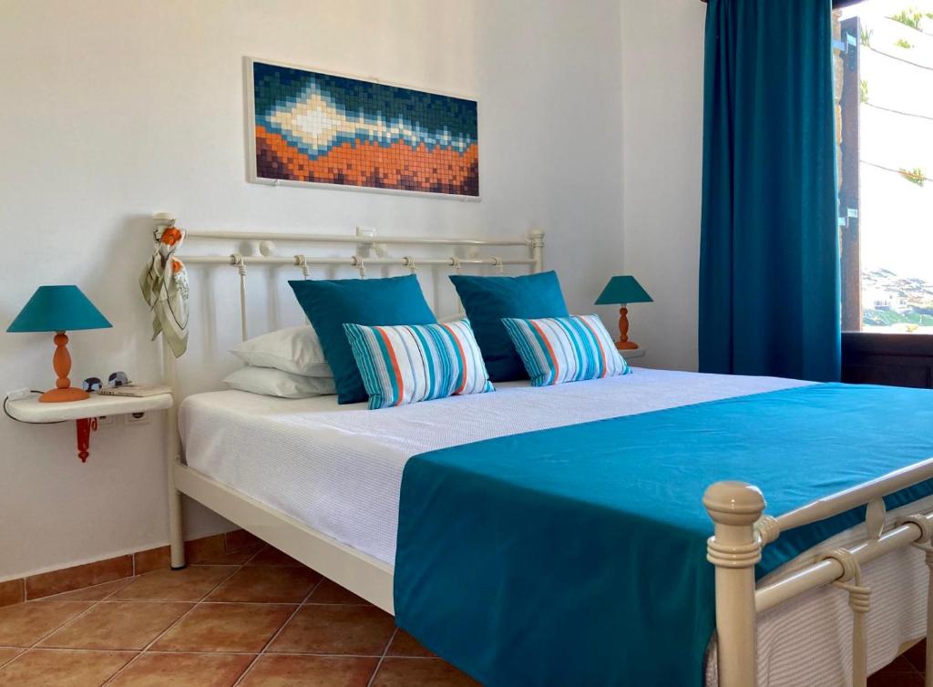 una camera da letto con un grande letto con lenzuola e cuscini blu di SYROU LOTOS Studios & Apartments a Kinion