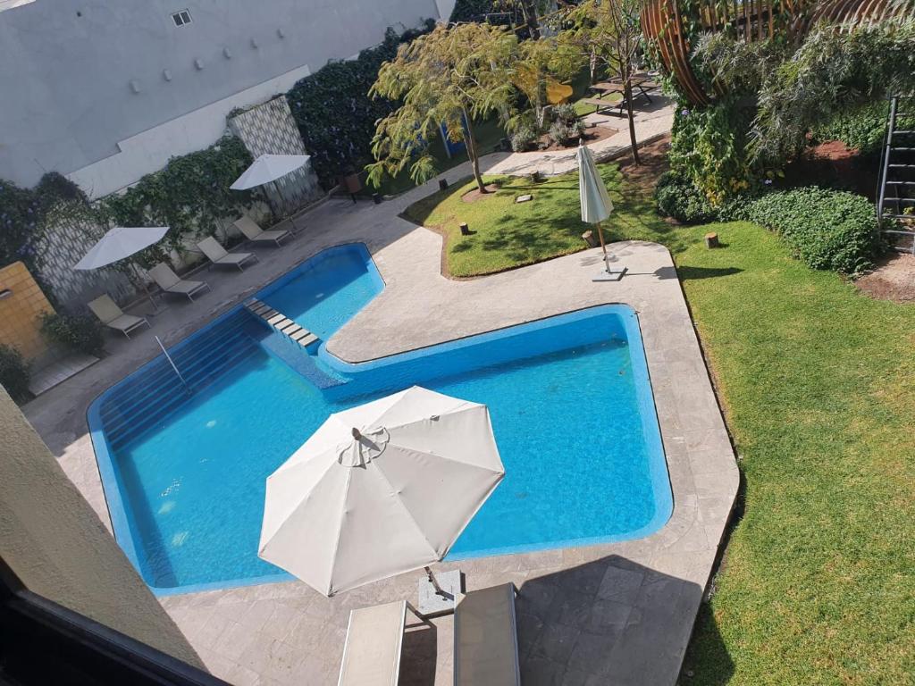 uma vista superior de uma piscina com um guarda-sol em Guadalajara hermoso con Gym, Alberca, Billar, confortable y acogedor em Guadalajara