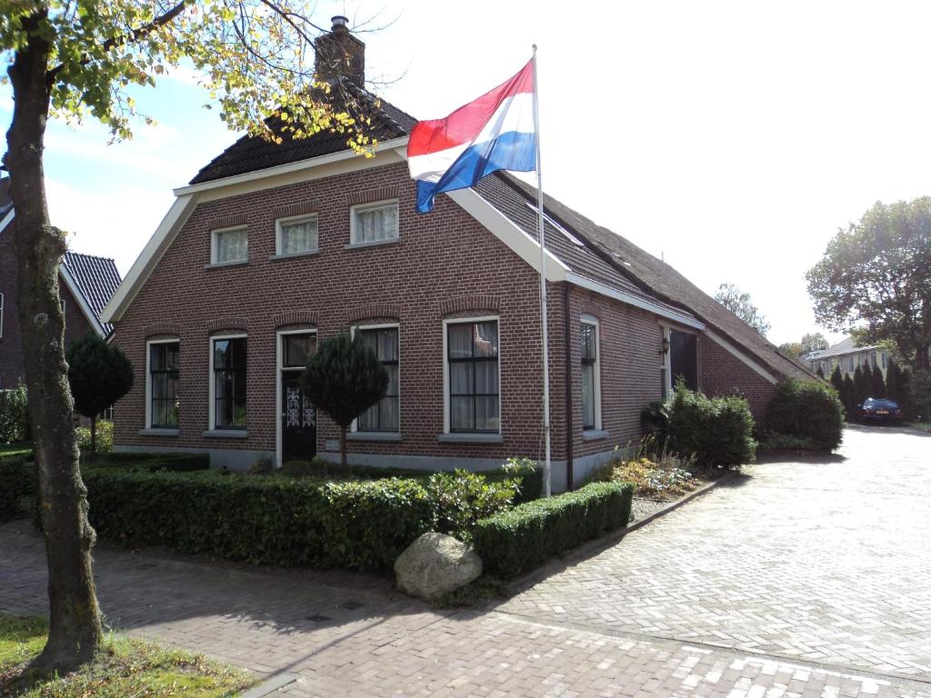 een vlag voor een bakstenen gebouw bij Hubertushoeve in Diever