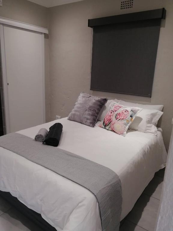 a bedroom with a large white bed with pillows at 394OnEmus in Pretoria